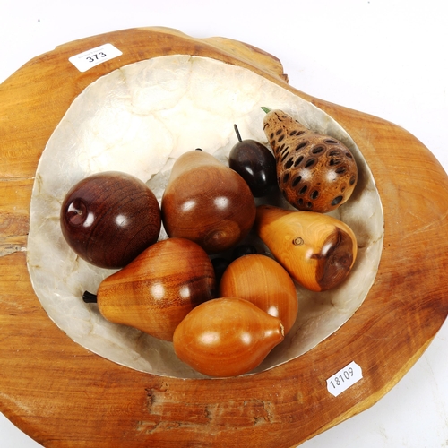 373 - A group of polished hardstone orbs, carved hardwood fruit, mother-of-pearl mounted fruit bowl etc