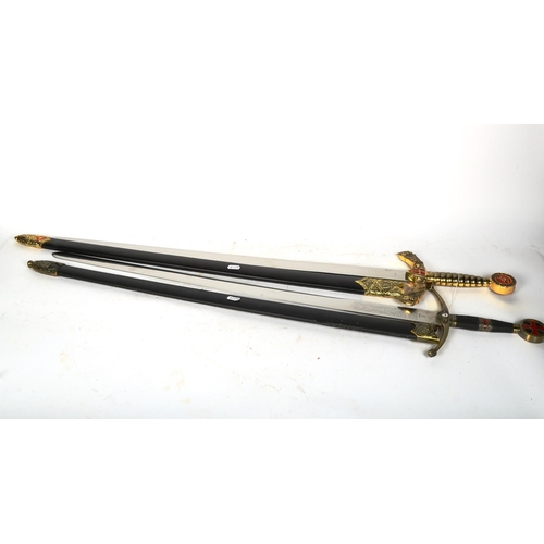 534 - A reproduction replica Toledo sword in scabbard, and a sword ornament