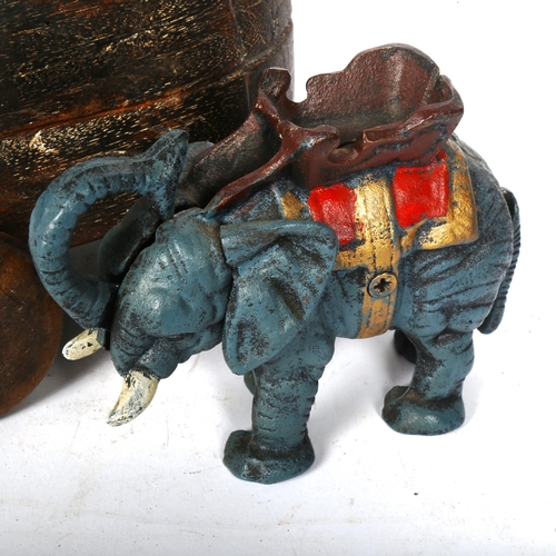 549 - A cast-iron elephant novelty money box, and a carved wood elephant box on wheels, height 18cm