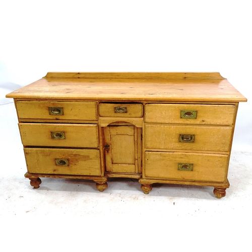 2126 - A 1930s pine sideboard, with 7 drawers and small central cupboard, W152cm, H80cm, D59cm