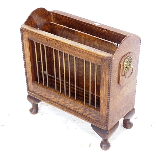 2312 - An early 20th century oak magazine rack, with brass lion mounts, L50cm, H47cm, D21cm