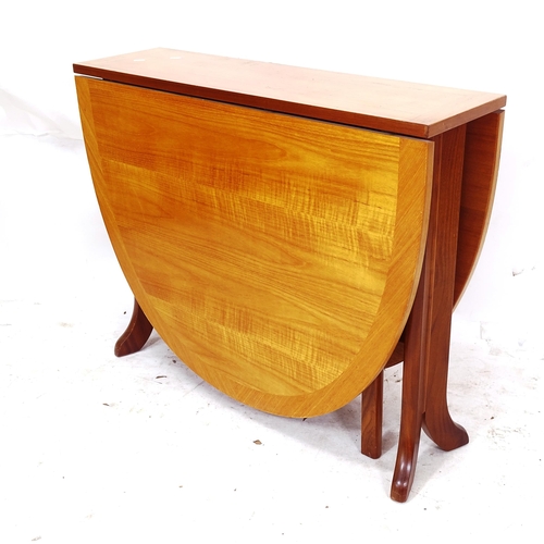 2313 - A contemporary light oak and mahogany oval gateleg dining table, L92cm, H76cm, D26cm, extending to 1... 