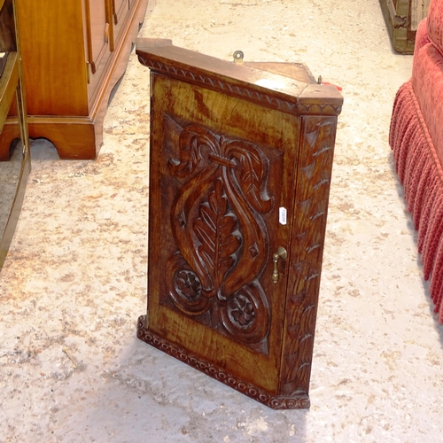 2648 - A small Antique oak hanging corner cabinet, with relief carved door, W38cm, H50cm