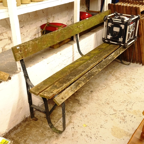 2716 - A weather slatted hardwood garden bench, on scrolled ends, L183cm