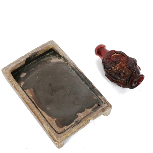 819 - A Chinese slate ink stone, and a small red amber snuff bottle (2)