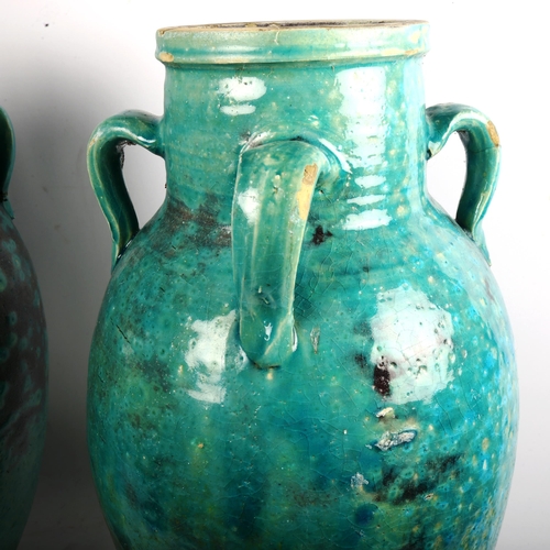 878 - A large pair of Hamadan turquoise glaze pottery oil jars, height 54cm (1 A/F)