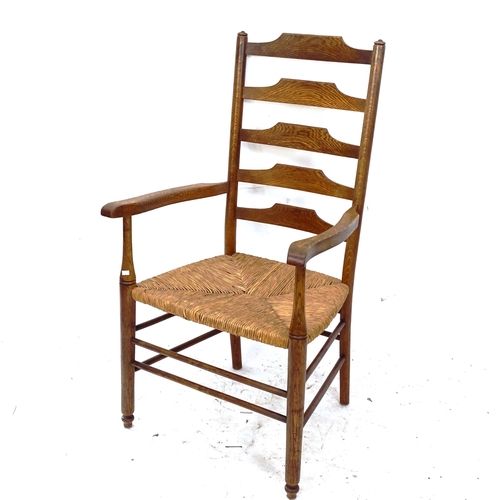 2140 - An Arts and Crafts Cotswold School ladder-back armchair, with rush seat