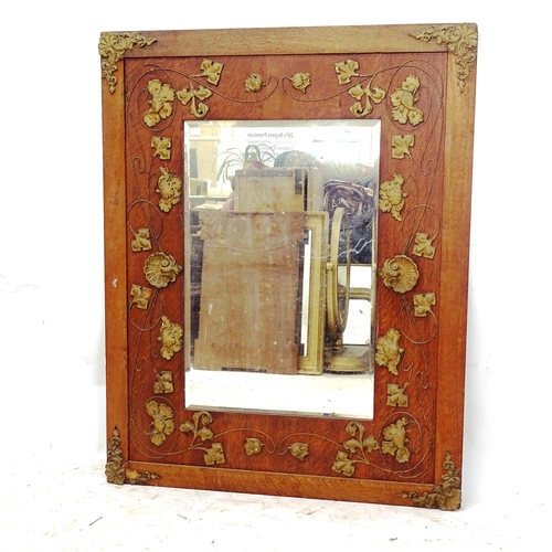 2152 - A panelled oak rectangular framed bevel-edge wall mirror, with applied gilded decoration, 120cm x 93... 