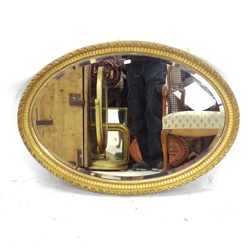 2159 - A carved giltwood bevel-edge oval wall mirror, W60cm, L86cm