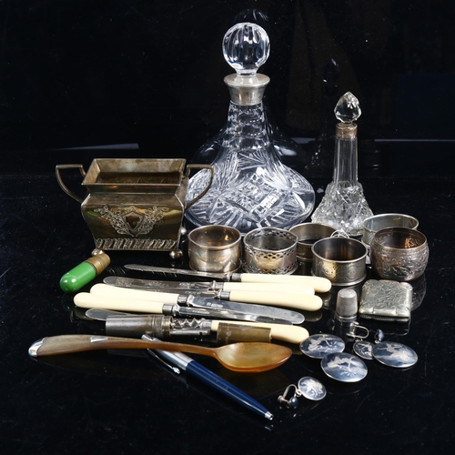 1003 - A set of 6 silver plated butter knives, 5 various silver napkin rings, a small ship's decanter with ... 