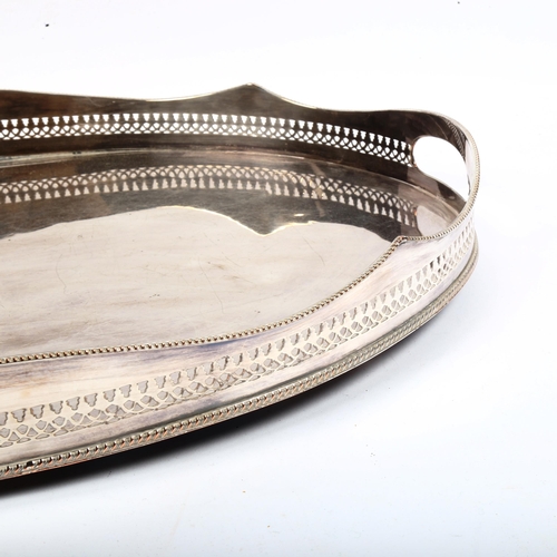 1053 - A silver plate on copper oval 2-handled serving tray, with pierced gallery