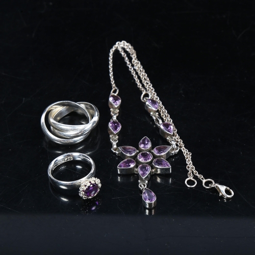 1064 - A silver and amethyst set star design drop pendant necklace, with matching ring, and a silver puzzle... 