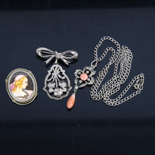 1082 - 3 Continental silver necklaces, to include a coral set drop pendant, a flower and ribbon drop pendan... 