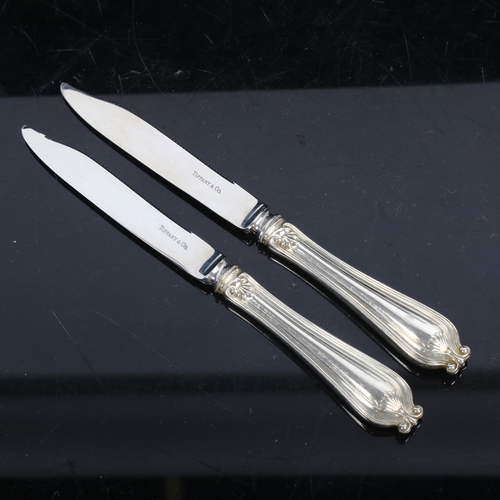 1125 - A pair of Tiffany & Co bread/butter knives, with serrated edges, mark to the blades and handles