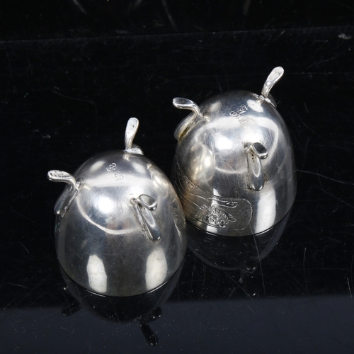 1126 - A pair of Continental silver egg cups, with engraved lion decoration on 3 feet, stamped 800