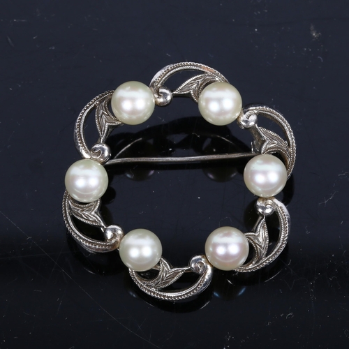 1188 - K MIKIMOTO TOKYO - an interwoven circular marcasite and pearl set brooch, stamped to the back