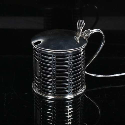 1194 - A George V silver pierced drum mustard pot and cover, with blue glass liner, London 1912