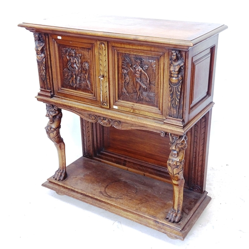 2303 - An Antique walnut Continental cabinet on stand, with 2 panelled doors and figural carved decoration,... 