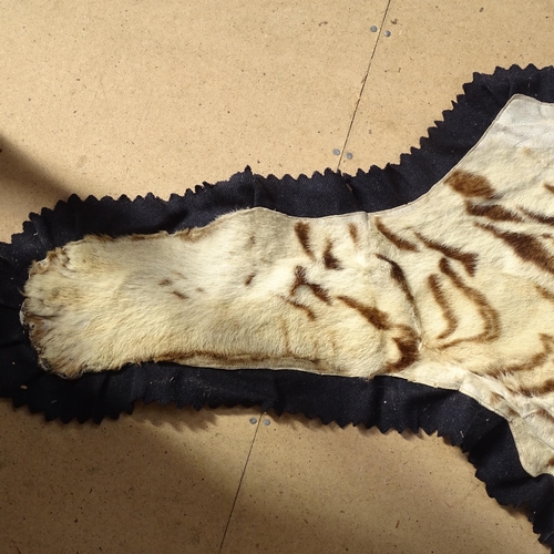 872 - TAXIDERMY - a tiger skin rug, early 20th century, modelled with head baring teeth, on a felt backing... 