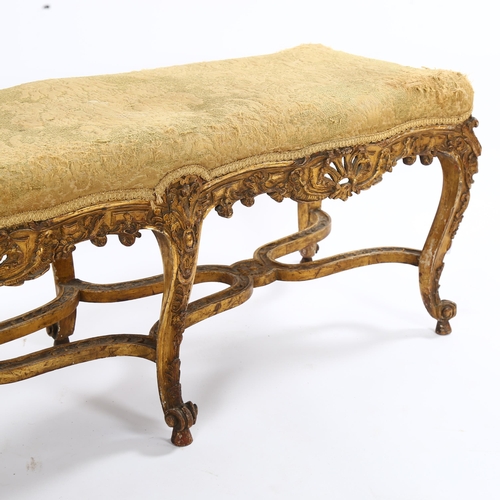 1398 - An ornate 19th century carved giltwood duet stool, raised on 6 cabriole legs with cross stretchers, ... 