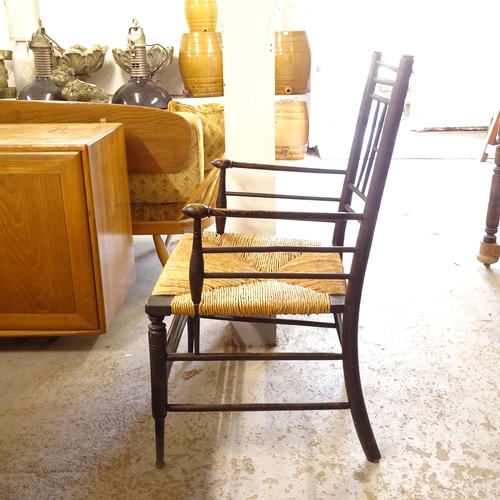 2677 - Liberty - an Antique ebonised Sussex style elbow chair with rush seat