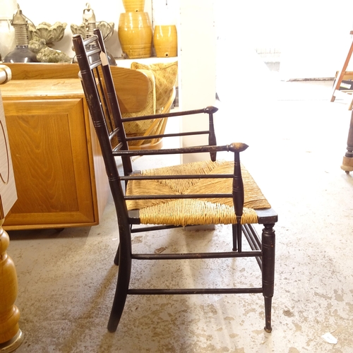 2677 - Liberty - an Antique ebonised Sussex style elbow chair with rush seat