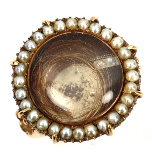 156 - A large 19th century pearl cluster mourning ring, central hair panel beneath convex crystal with bor... 