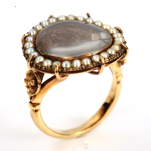 156 - A large 19th century pearl cluster mourning ring, central hair panel beneath convex crystal with bor... 