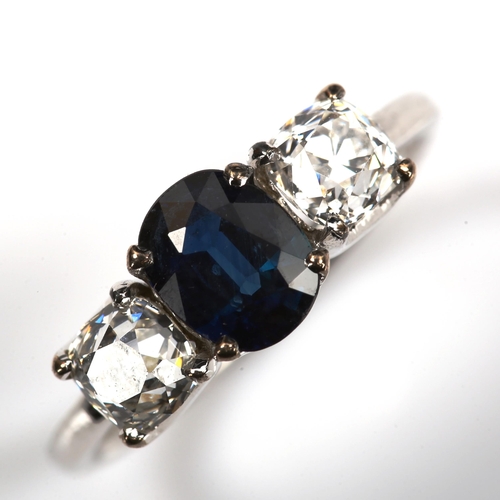 168 - A three stone sapphire and diamond ring, unmarked white metal settings with oval mixed-cut sapphire ... 