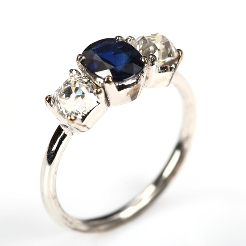 168 - A three stone sapphire and diamond ring, unmarked white metal settings with oval mixed-cut sapphire ... 