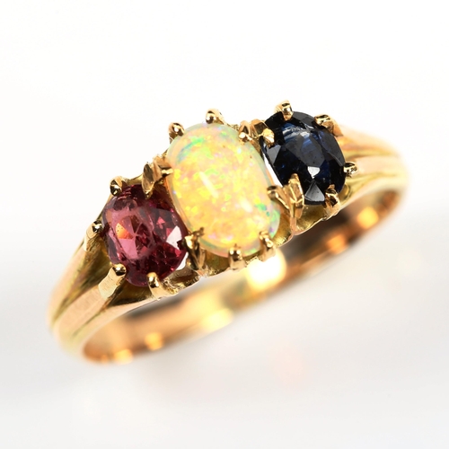 172 - An three stone opal sapphire and garnet half hoop ring, unmarked gold settings with oval cabochon op... 