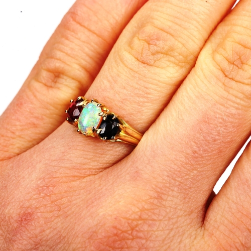 172 - An three stone opal sapphire and garnet half hoop ring, unmarked gold settings with oval cabochon op... 