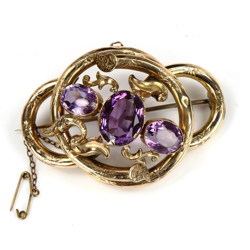 201 - A large Victorian amethyst knot brooch, unmarked yellow metal settings with floral engraved decorati... 