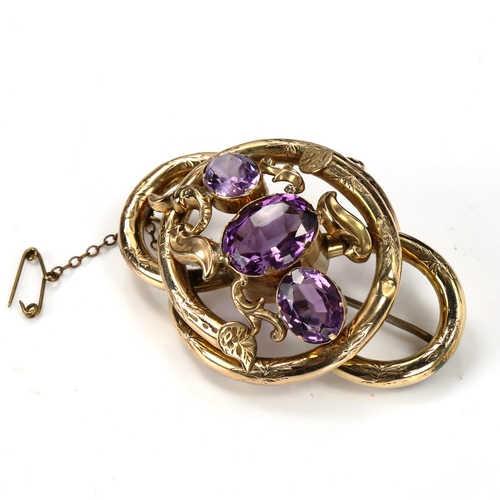 201 - A large Victorian amethyst knot brooch, unmarked yellow metal settings with floral engraved decorati... 