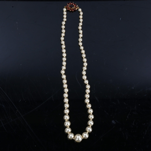 202 - A Vintage graduated single-row pearl necklace, with garnet set 9ct gold clasp, hallmarks London 1985... 