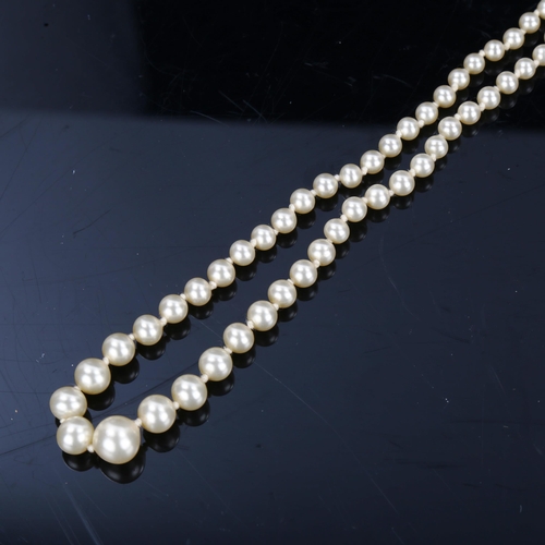 202 - A Vintage graduated single-row pearl necklace, with garnet set 9ct gold clasp, hallmarks London 1985... 