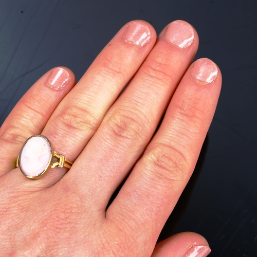 205 - An unmarked gold relief carved pink coral cameo ring, depicting female profile, setting height 16mm,... 