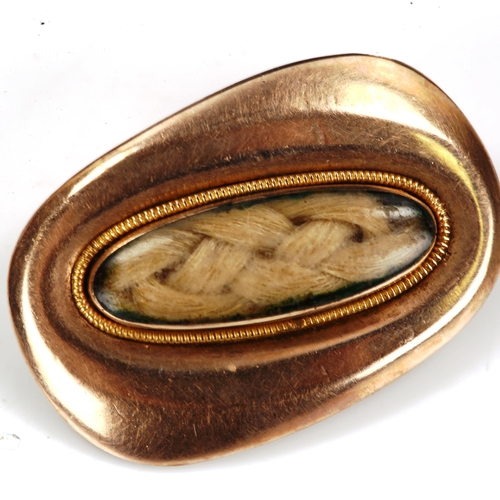 206 - A small Georgian unmarked gold mourning brooch, central oval woven hair panel under convex glass wit... 