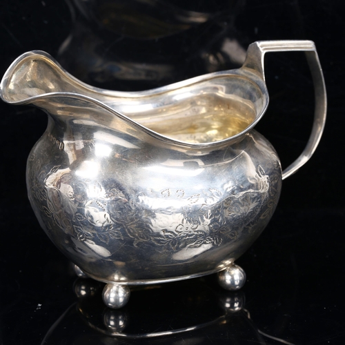 212 - A George III silver cream jug, bright-cut engraved floral decoration with gilt interior and bun feet... 