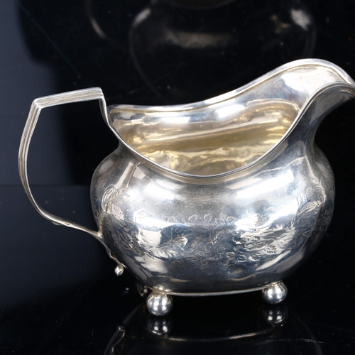 212 - A George III silver cream jug, bright-cut engraved floral decoration with gilt interior and bun feet... 