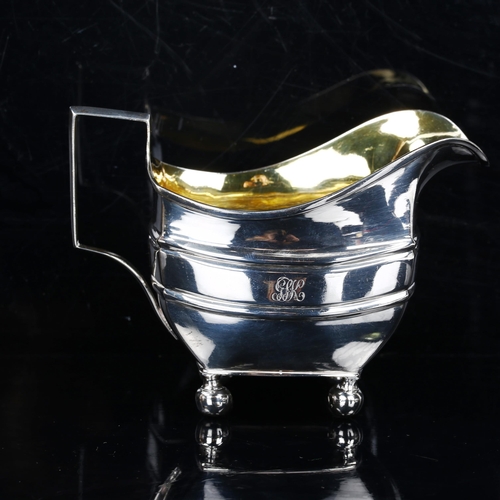 216 - A George III silver cream jug, with gilt interior on bun feet, indistinct maker's marks, hallmarks L... 