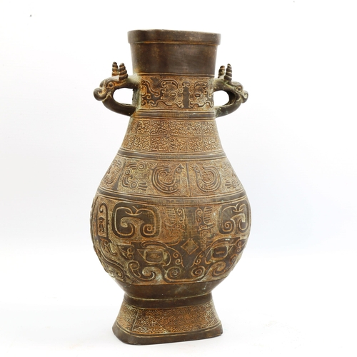 1006 - A Chinese Archaic style bronze vase, with relief decoration and dragon handles, height 30cm