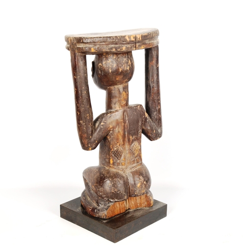 1022 - African Tribal carved wood stool in the form of a crouching figure, height 34cm