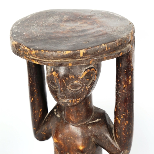 1022 - African Tribal carved wood stool in the form of a crouching figure, height 34cm