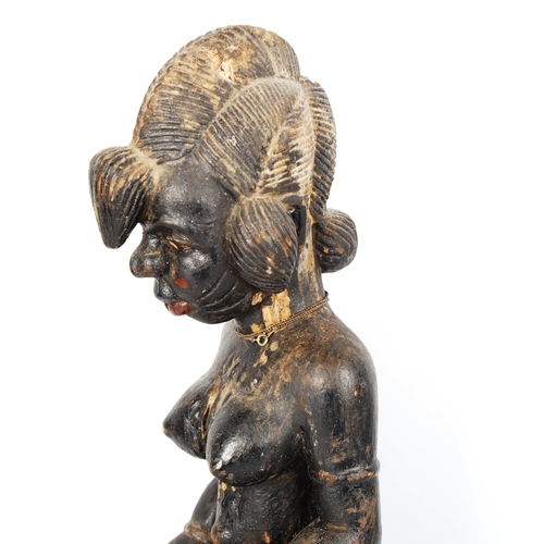 1023 - African carved and painted wood female seated figure, height 39cm