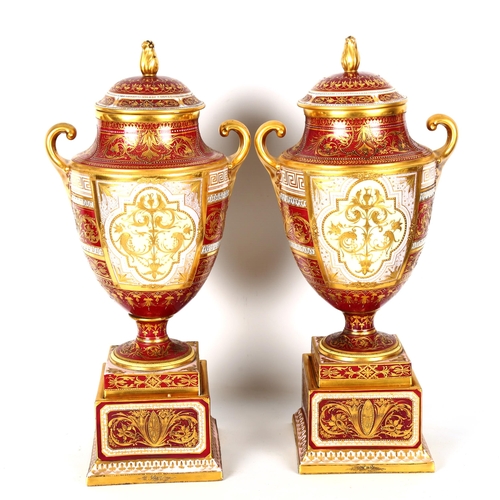 1121 - A fine pair of early 20th century Vienna porcelain urns and covers, with hand painted panels depicti... 