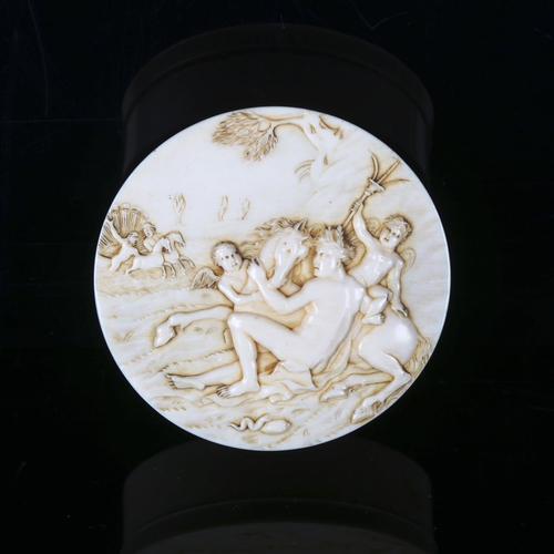 1133 - A French circular ivory box, 18th or 19th century, the lid carved in relief depicting satyres, diame... 