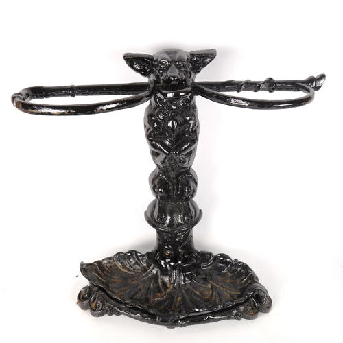 1179 - A cast-iron stick stand in the form of a dog holding a riding crop, with removeable tray base