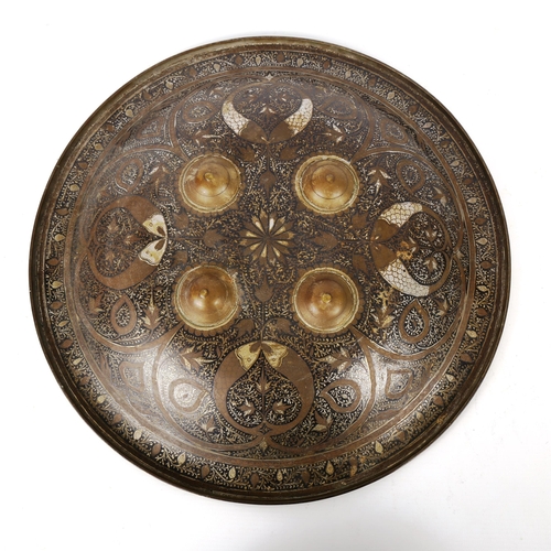 1217 - A Middle Eastern Islamic brass and enamel shield with engraved decoration, diameter 37cm