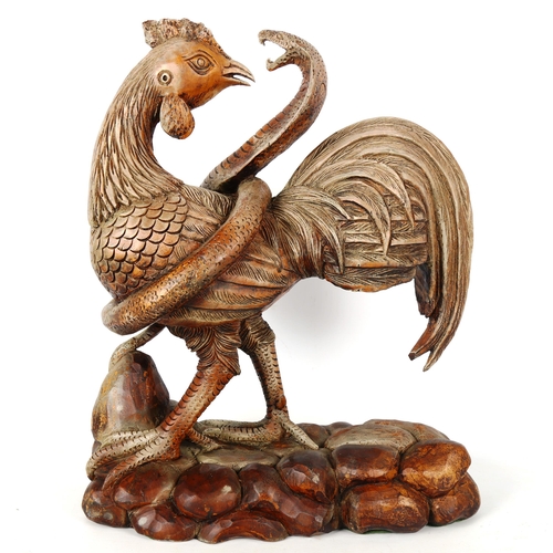 1262 - A carved and painted wood sculpture of a cobra and cockerel, height 43cm